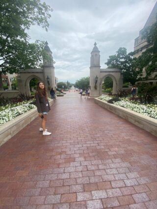 A picture of IU's Sample Gates with a woman standing to the left.