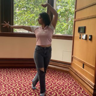 A person strikes a pose in Presidents Hall within Franklin Hall
