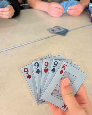 A student holds playing cards