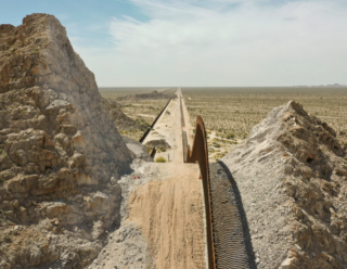 A frame from “American Scar” depicting the U.S.-Mexico border going through a mountain.