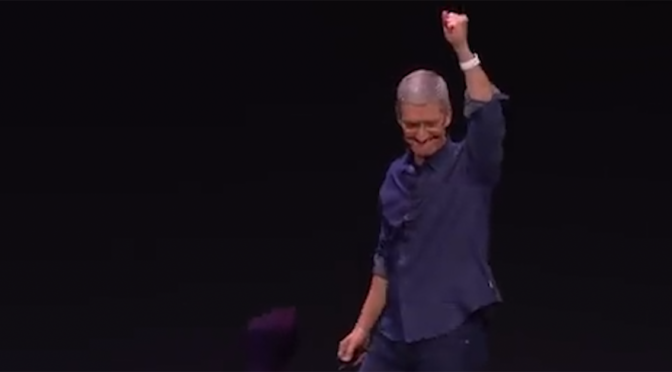 Apple CEO Tim Cook raises his hand over the crowd after receiving a standing ovation for the new Apple Watch technology.