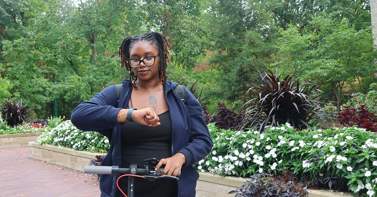 Student using Apple Watch outside class.