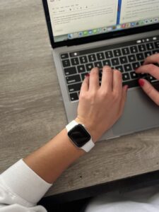 Student displays her apple watch while completing her homework.