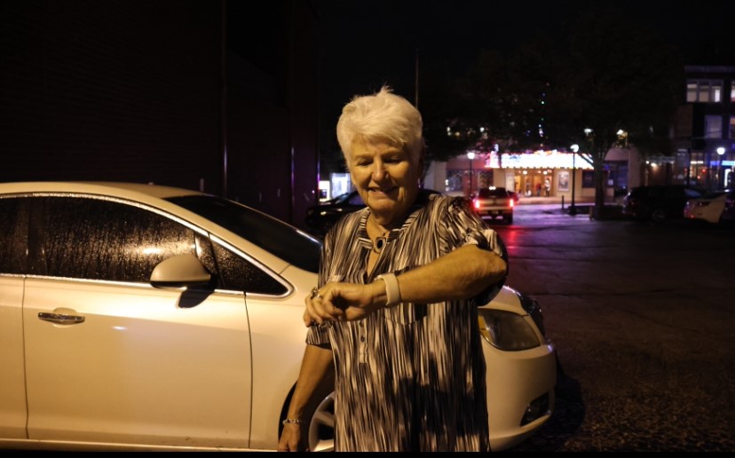 An elderly woman uses her Apple Watch to navigate.