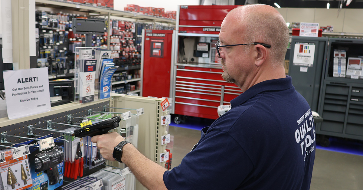 Male worker scans item on ticket scanner