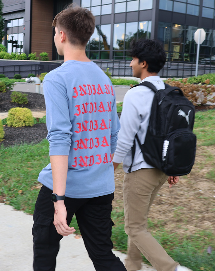 2 highschoolers walking while their apple watches track their steps