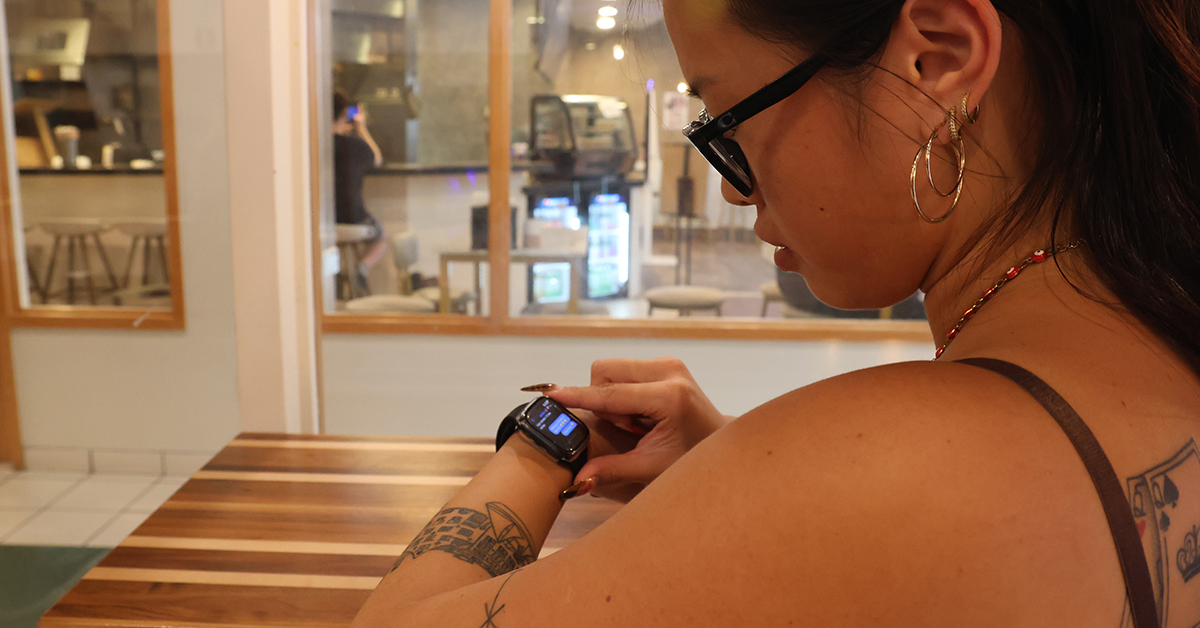 A young woman using her Apple Watch to text other employees. 