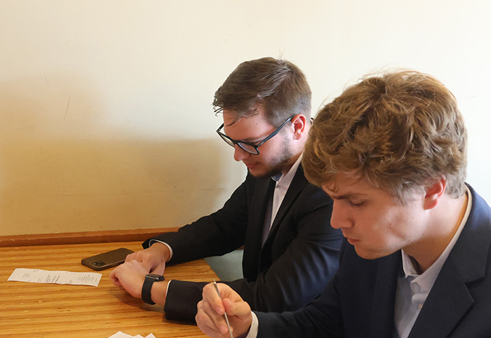 Tutor enjoys apple watch while eating with his peers