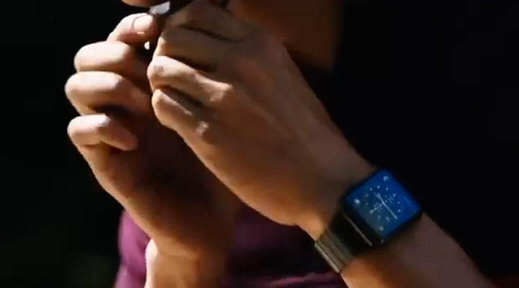 A biker fastens his helmet, displaying an Apple Watch on his wrist.