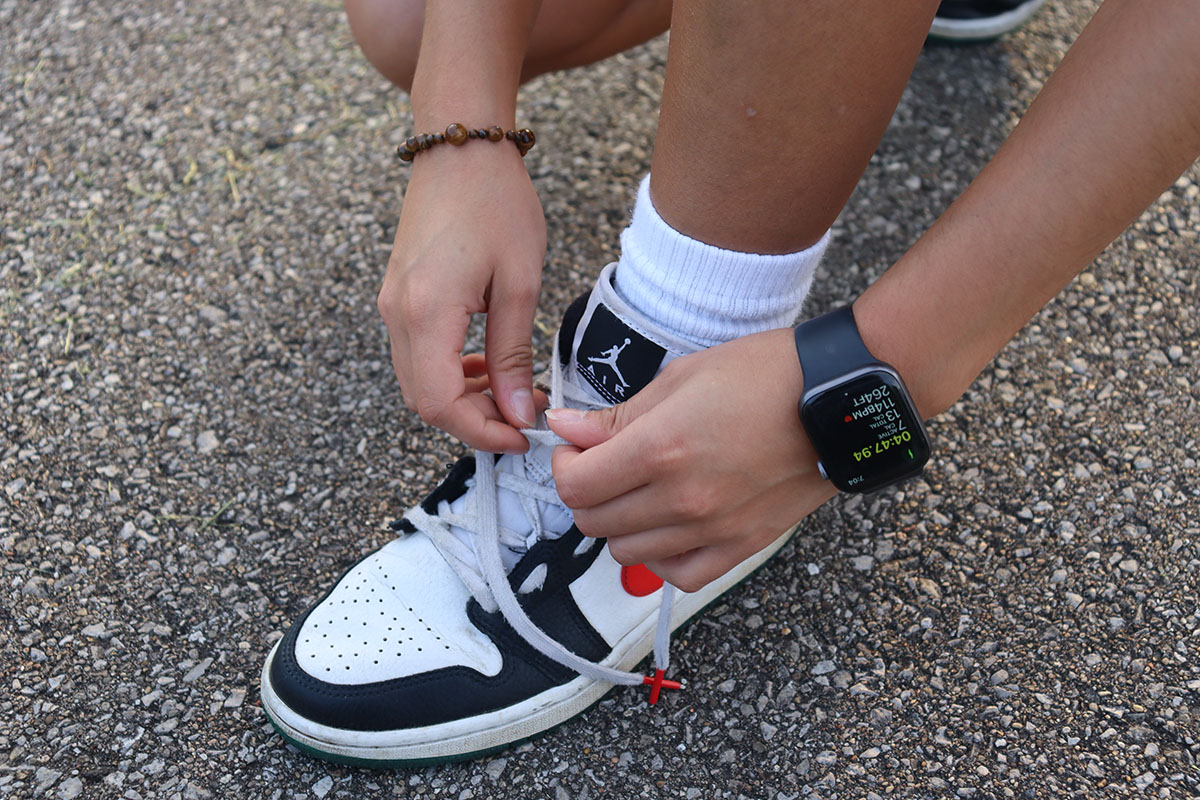 Women tying shoe with Apple Watch