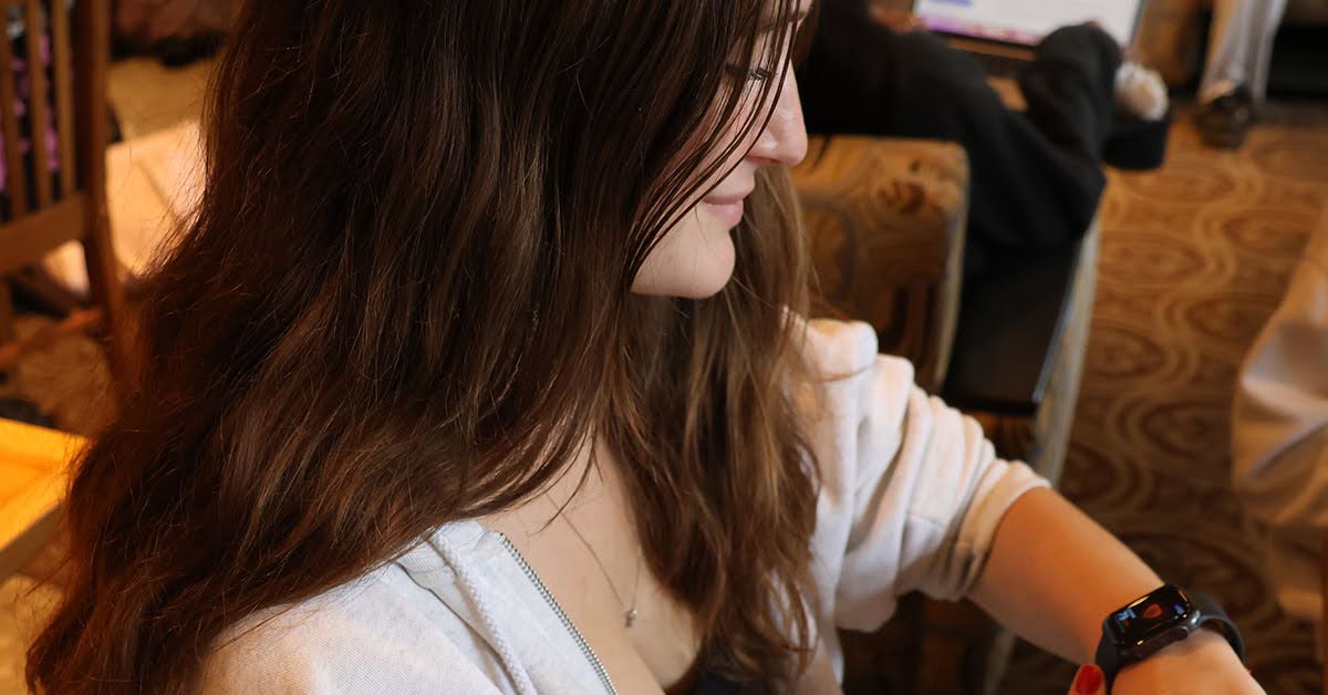 College student smiles because she loves her Apple Watch