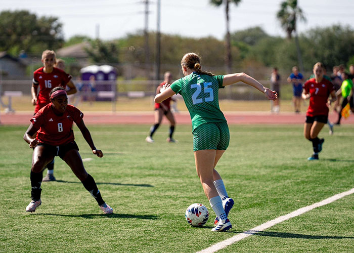 Lucca Okeley dribbles soccer ball against defenders.