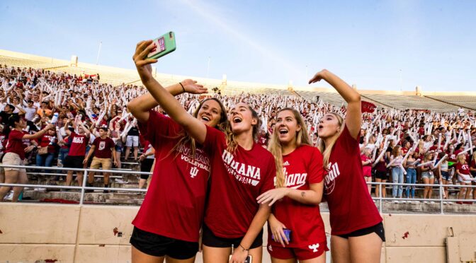 Indiana University volleyball players take a selfie in front of student section.