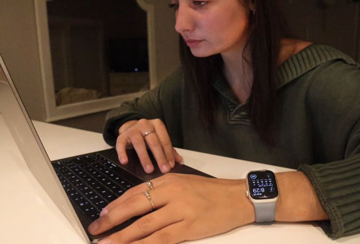 Young woman working on homework and wearing her Apple Watch.