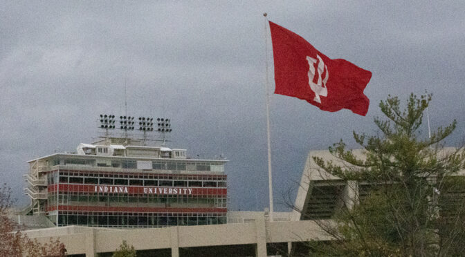 The flag blows in front of the Indiana University football stadium, where NIL has become a recent topic for discussion.