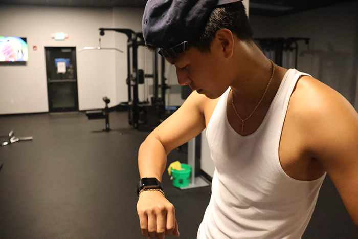 Gym enthusiast looks at Apple Watch to see fitness progress.