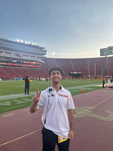 picture of young man on football field posing with a peace sign