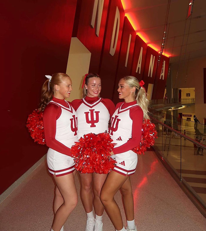 Three Indiana University Sophomore Cheerleaders smile at each other before a game. Photo by Megan Liebhaber.