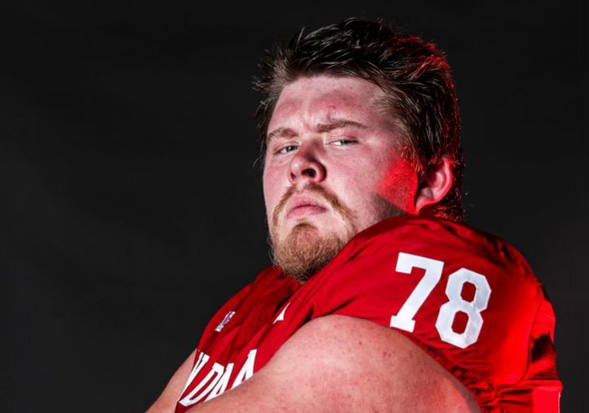 Cooper Jones, clad in a red football jersey with the numbers 78, poses in front of the camera.