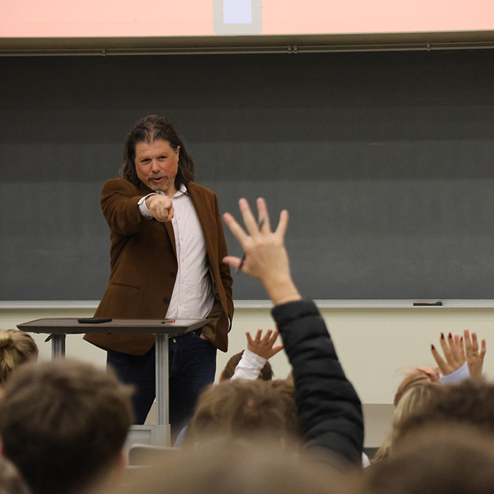 A professor points at a student, answering their questions,