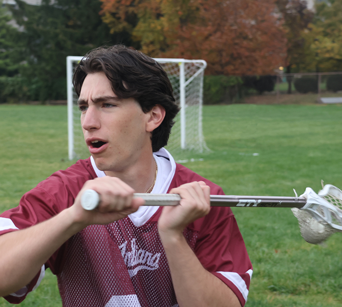 A Lacrosse Player prepares pass to his teammate.