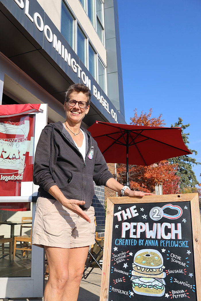 Sue Aquia poses in front of her business, Bloomington Bagel Company. 