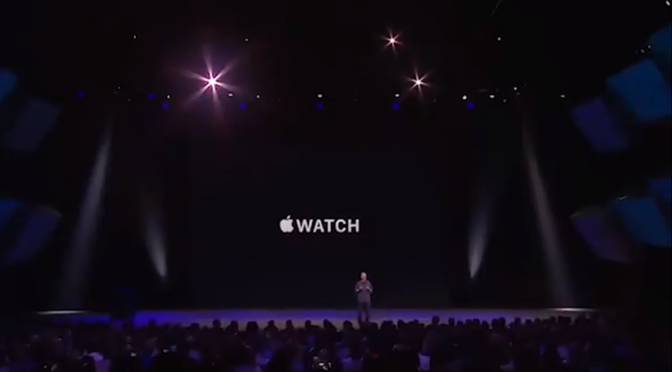 Tim Cook standing in front of a project screen that says "Apple Watch".