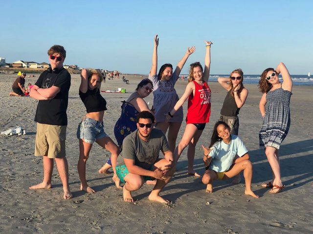 Students pose on a beach