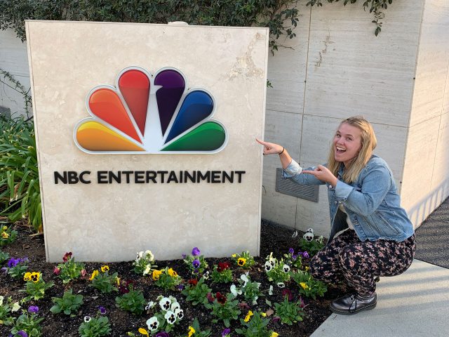 Kathryn Jankowski stands with the NBCUniversal sign in L.A.