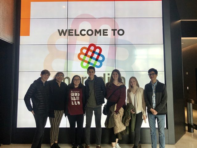 Media LLC Students pose in front of a digital screen in the Meredith lobby