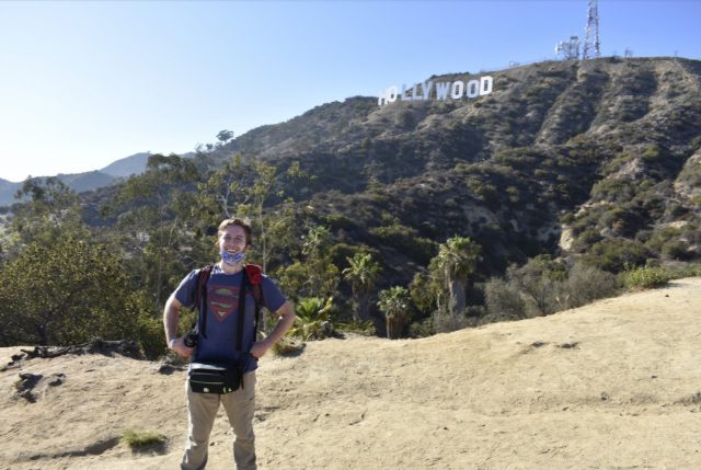 Brandon Dananay stands in front of the Hollywood sign smiling