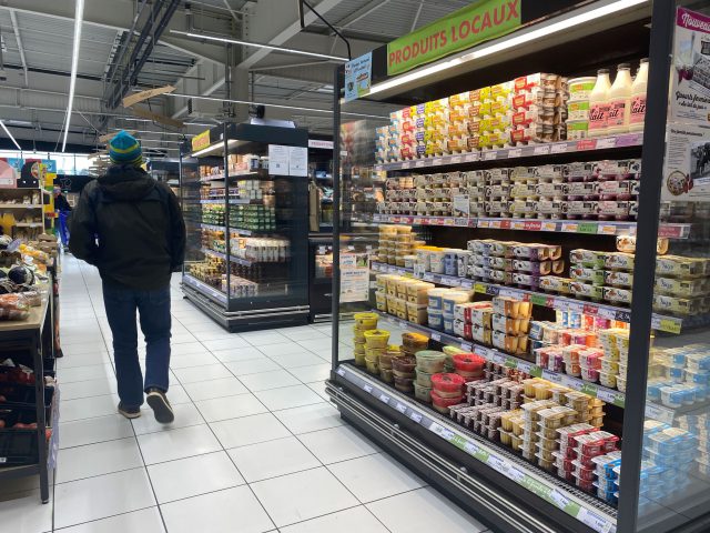 A person walks among the supermarket aisles.