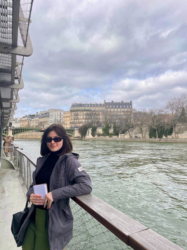 a woman stands near the Seine River